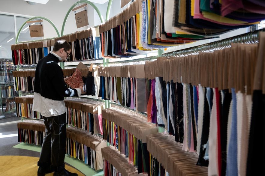 Le créateur espagnol Arturo Obegero regarde des tissus non utilisés par les grandes maisons de luxe du groupe LVMH, revendus dans le showroom de Nona Source, le 14 mars 2024 à Paris